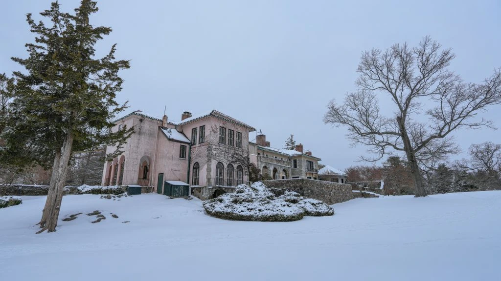 A winter estate garden on a Wisconsin ridge, with a dry-stack limestone wall, red twig dogwood, and white pine under fresh snow.